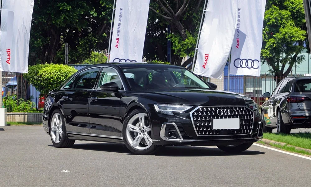Фото Audi A8 L (2024) — вид спереди, фото 7. Передок в чёрном исполнении — крупная светотехника и выразительный бампер. Дневные ходовые огни включаются автоматически с запуском Audi A8 L (2024) — вид спереди, фото 7