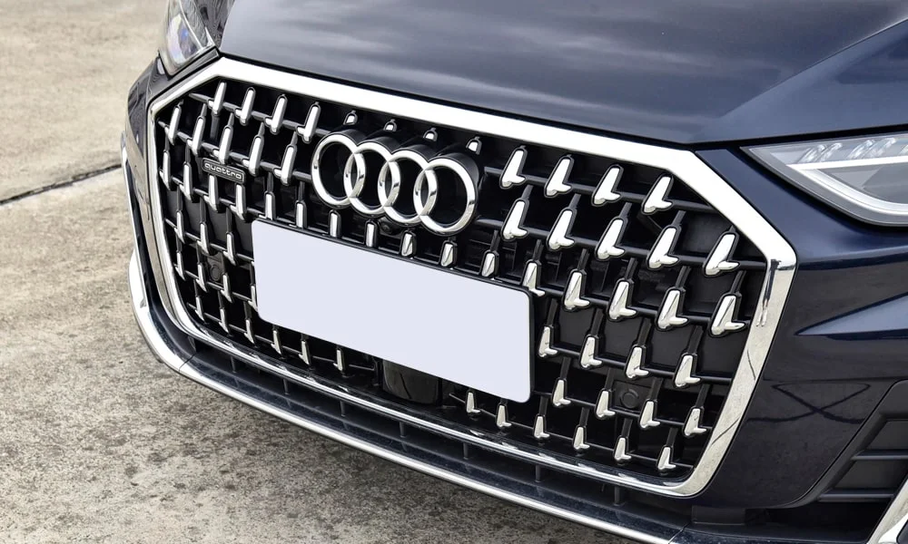 Фото Audi A8 L (2024) — решётка радиатора. Фирменный рисунок облицовки — визитная карточка марки. Активные жалюзи за решёткой закрываются на трассе ради аэродинамики — есть у ряда моделей Audi A8 L (2024) — решётка радиатора