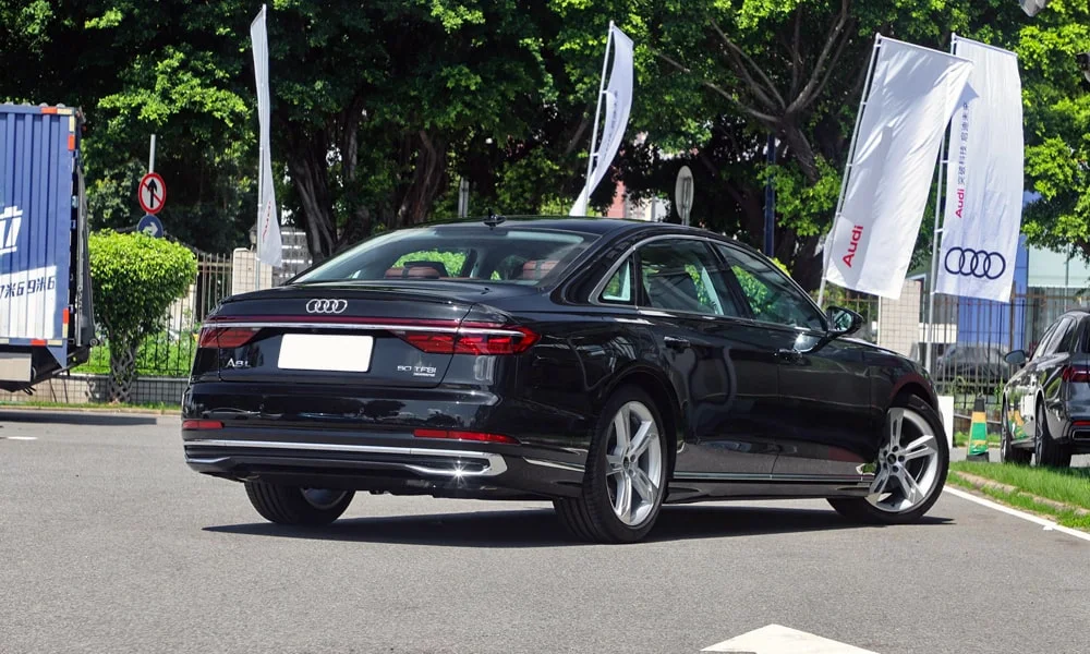 Фото Audi A8 L (2024) — вид сзади, фото 7. Корма в чёрном цвете: графика фонарей и пластика пятой двери. Насадки выхлопа или их имитация внизу бампера различают версии Audi A8 L (2024) — вид сзади, фото 7
