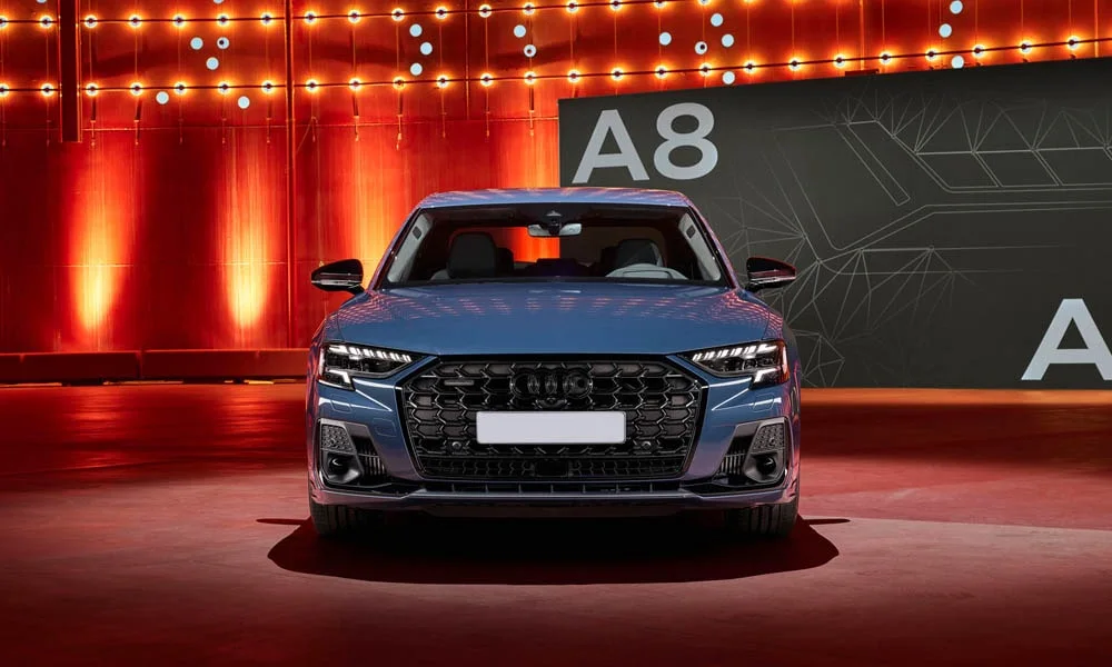 Фото Audi A8 (2024) — вид спереди, фото 7. Синий кузов, строгая симметрия оптики — базовый ракурс знакомства с дизайном Audi A8 (2024) — вид спереди, фото 7