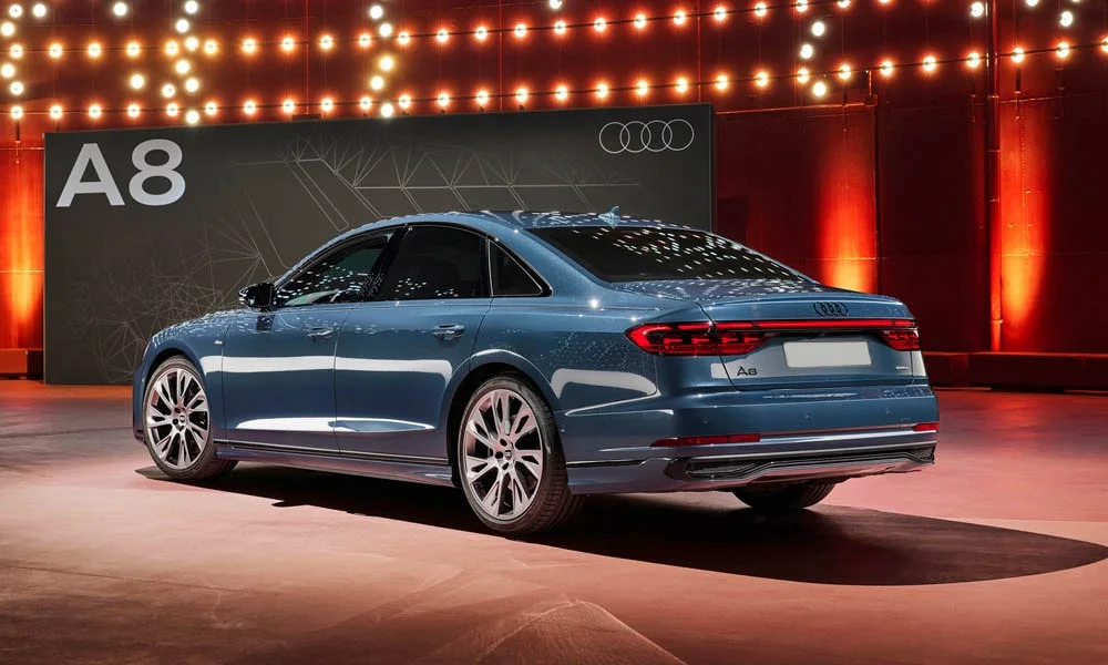 Фото Audi A8 (2024) — вид сзади, фото 10. Синий кузов сзади — фонари и бампер определяют ночной образ модели. Светодиодная полоса или раздельные секции — задняя оптика стала главным украшением кормы Audi A8 (2024) — вид сзади, фото 10