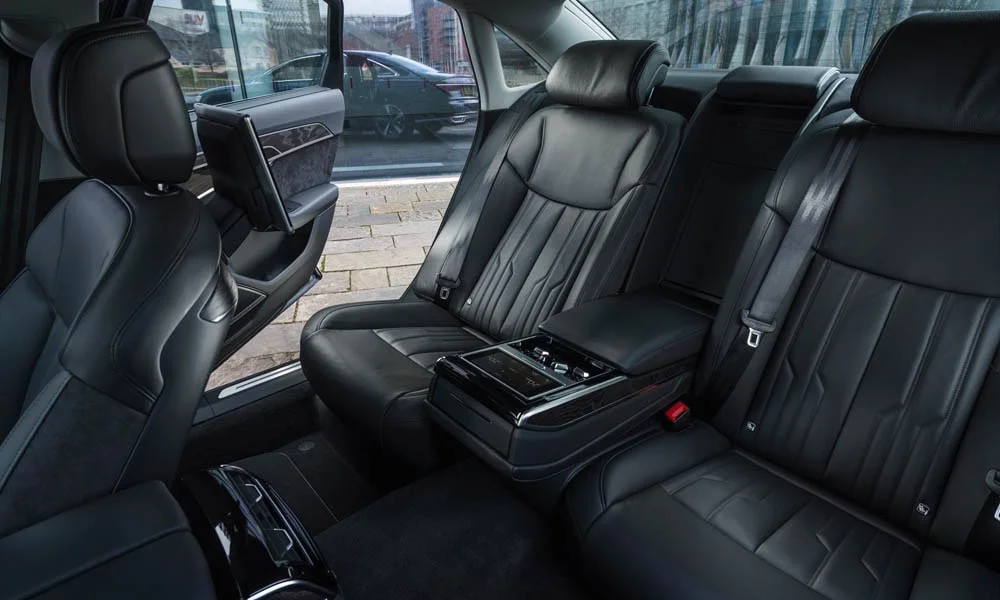 Фото Audi A8 (2024) — задние сиденья. Второй ряд: профиль дивана, подголовники и обивка из гладкой коже. Крепления ISOFIX для детских кресел — в основании спинки Audi A8 (2024) — задние сиденья