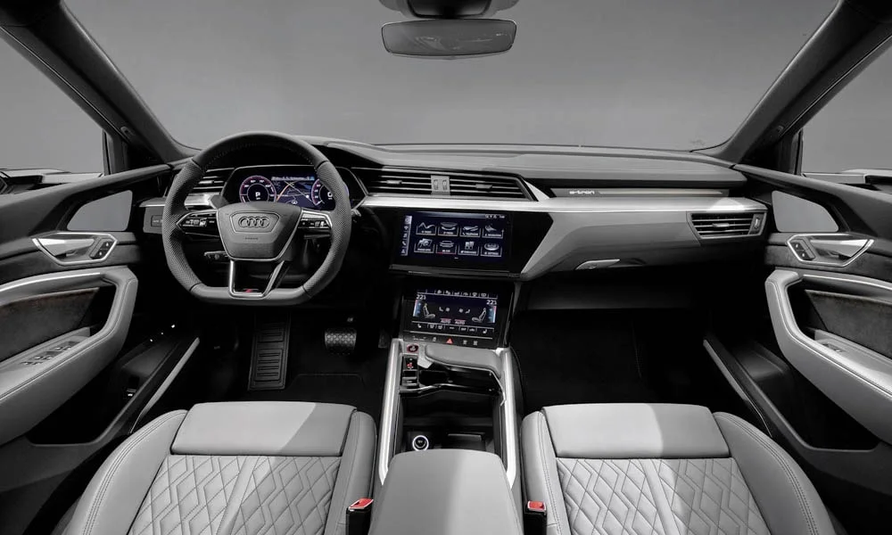 Фото Audi e-tron S — передняя панель. Панель в светло-серой отделке — видна компоновка экранов и органов управления. Мягкие материалы верхнего яруса и вставки задают уровень интерьера Audi e-tron S — передняя панель