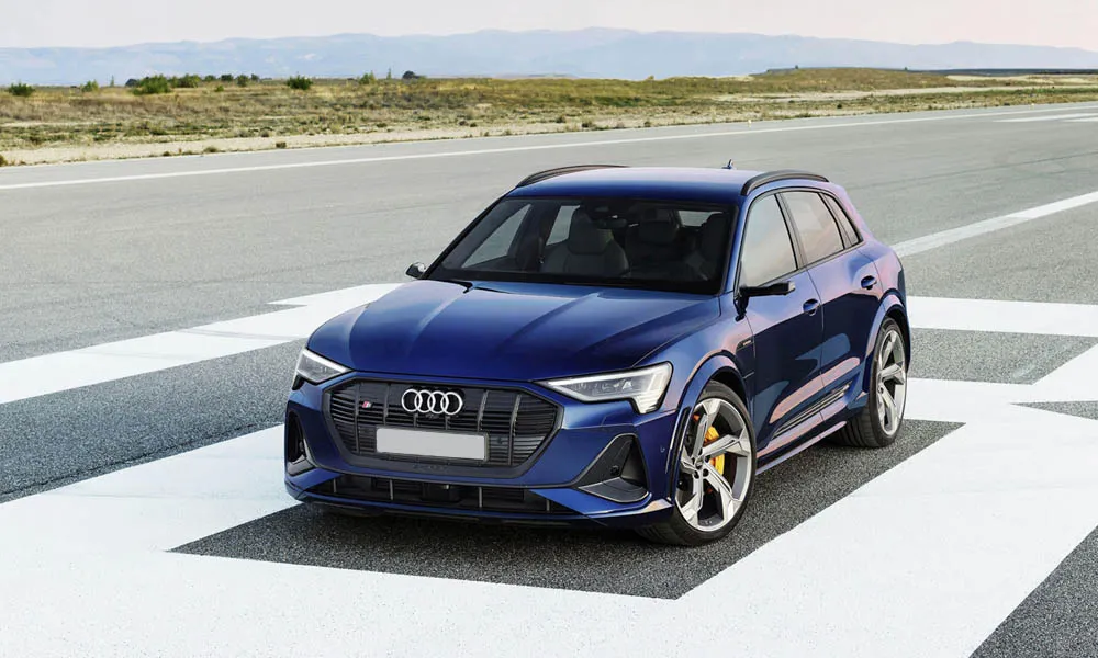 Фото Audi e-tron S — вид спереди, фото 7. Передок в синем исполнении — крупная светотехника и выразительный бампер. Дневные ходовые огни включаются автоматически с запуском Audi e-tron S — вид спереди, фото 7