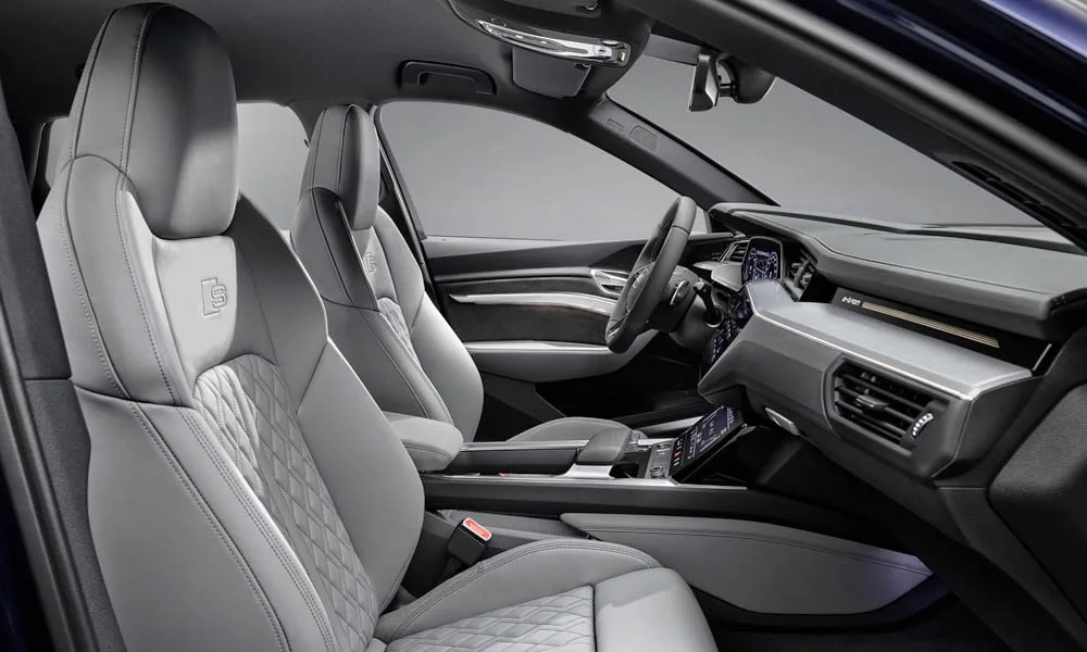 Фото Audi e-tron S — передние сиденья. Передние кресла в перфорированной коже. Регулировки с памятью возвращают кресло под водителя одним нажатием — у версий с электроприводом Audi e-tron S — передние сиденья
