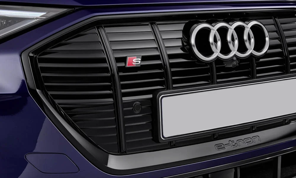 Фото Audi e-tron S — решётка радиатора. Рисунок решётки: сетка, ламели или глухая панель у электроверсий. Активные жалюзи за решёткой закрываются на трассе ради аэродинамики — есть у ряда моделей Audi e-tron S — решётка радиатора