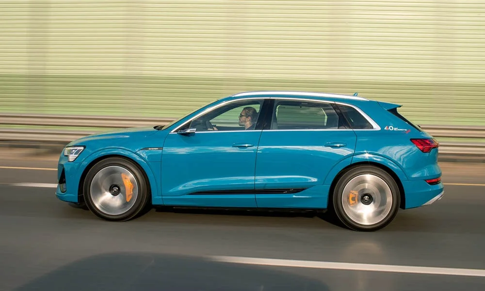 Фото Audi e-tron — вид сбоку, фото 2. Профиль в синем цвете: соотношение колёсной базы и свесов. Хромированные или чёрные молдинги окон отличают комплектации Audi e-tron — вид сбоку, фото 2