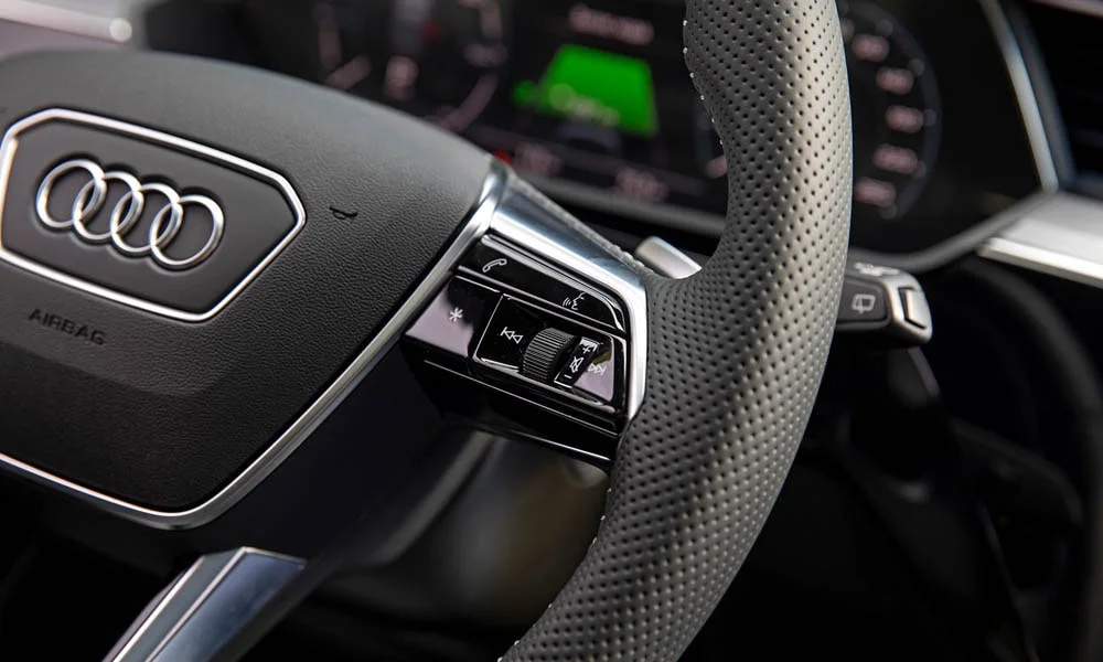 Фото Audi e-tron — руль. Обшивка обода и компоновка спиц крупным планом. Правильная посадка: руки на «9 и 3», приборы читаются поверх обода Audi e-tron — руль
