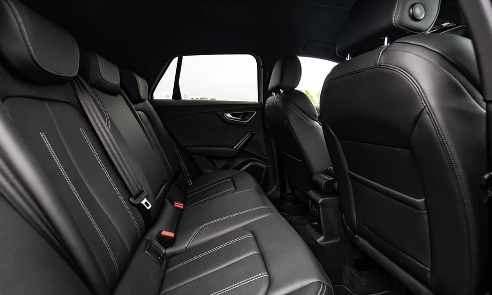 Фото Audi Q2 — задние сиденья. Посадка второго ряда: подголовники и подлокотник. Спинки складываются под длинные грузы у большинства версий Audi Q2 — задние сиденья