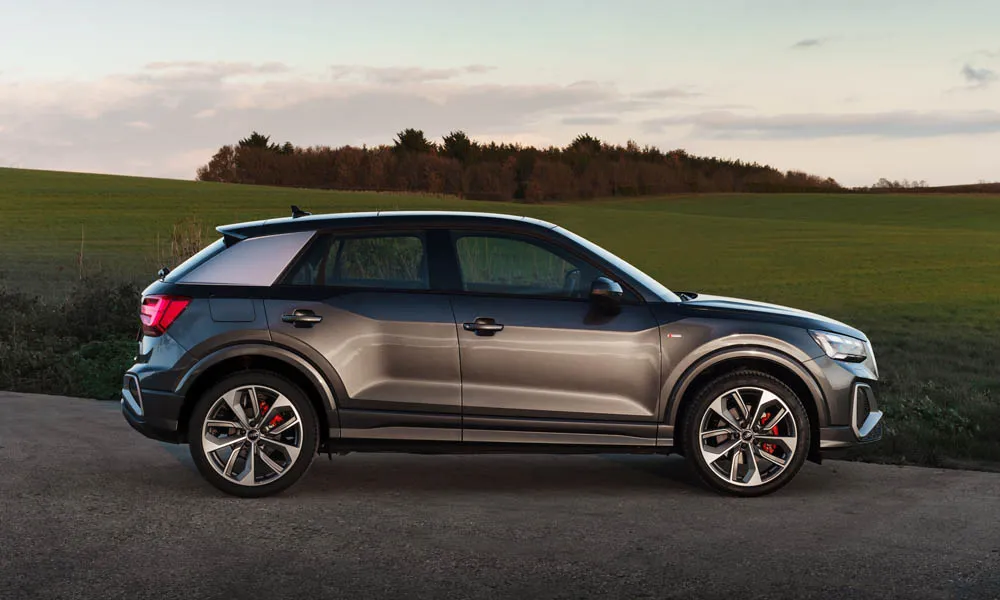 Фото Audi Q2 — вид сбоку, фото 2. Сбоку читаются линия остекления и характер выштамповок на сером кузове. Длинная база — простор второго ряда; короткие свесы упрощают парковку Audi Q2 — вид сбоку, фото 2