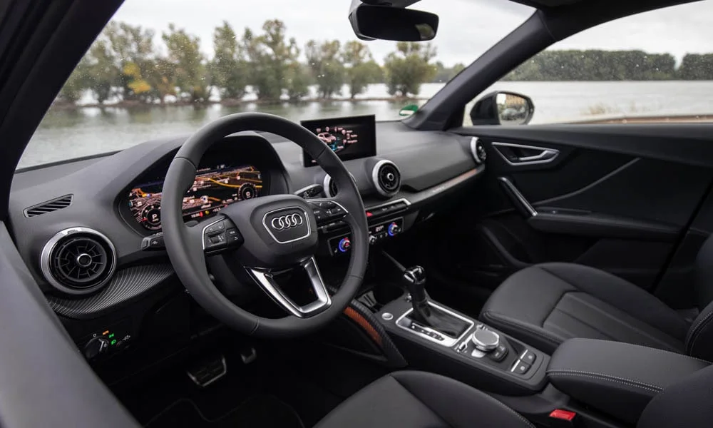 Фото Audi Q2 — руль. Обшивка обода и компоновка спиц крупным планом. Клавиши на спицах управляют медиа, круизом и ассистентами — руки остаются на руле Audi Q2 — руль