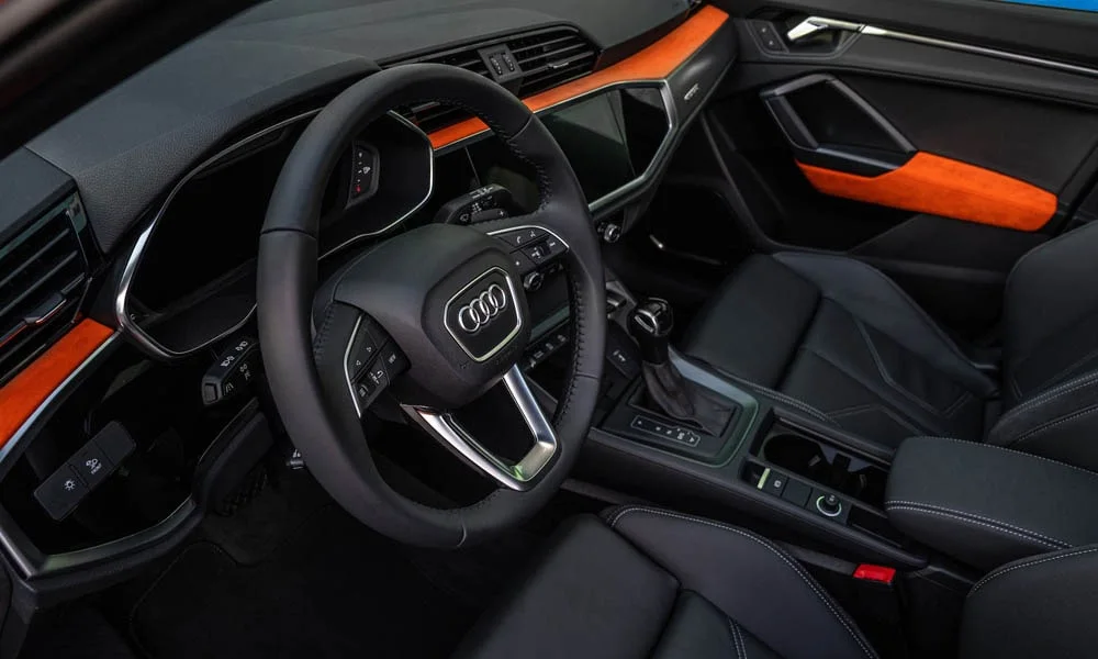 Фото Audi Q3 — передняя панель, фото 3. Панель в тёмной отделке — видна компоновка экранов и органов управления. Мягкие материалы верхнего яруса и вставки задают уровень интерьера Audi Q3 — передняя панель, фото 3