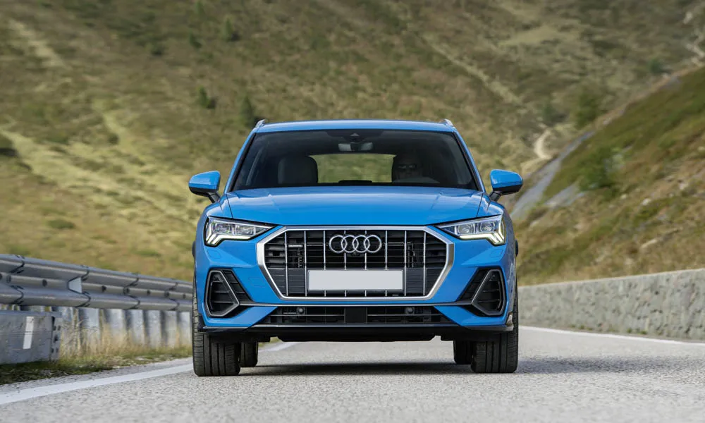 Фото Audi Q3 — вид спереди, фото 10. Кузов в синем цвете: рисунок оптики и решётки задаёт узнаваемое «лицо» модели. Дневные ходовые огни включаются автоматически с запуском Audi Q3 — вид спереди, фото 10