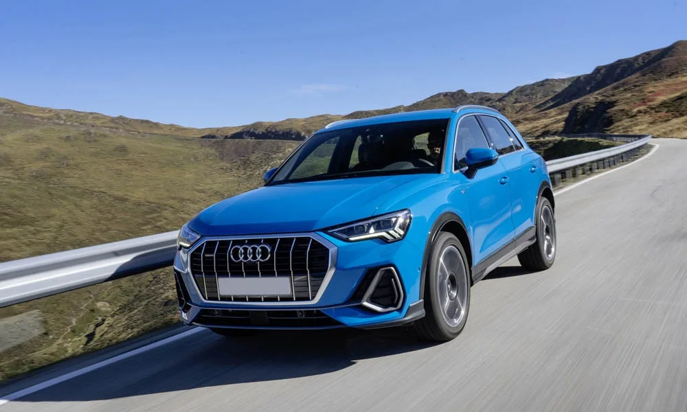 Фото Audi Q3 — вид спереди, фото 11. Кузов в синем цвете: рисунок оптики и решётки задаёт узнаваемое «лицо» модели. Рисунок ходовых огней — подпись модели, по нему её узнают в потоке Audi Q3 — вид спереди, фото 11