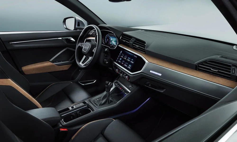 Фото Audi Q3 — интерьер. Общий план салона: архитектура панели, консоль и кресла. Светлая гамма зрительно расширяет салон, тёмная — практичнее в уходе Audi Q3 — интерьер