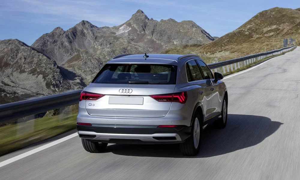 Фото Audi Q3 — вид сзади, фото 4. Корма в серебристом цвете: графика фонарей и пластика пятой двери. Светодиодная полоса или раздельные секции — задняя оптика стала главным украшением кормы Audi Q3 — вид сзади, фото 4