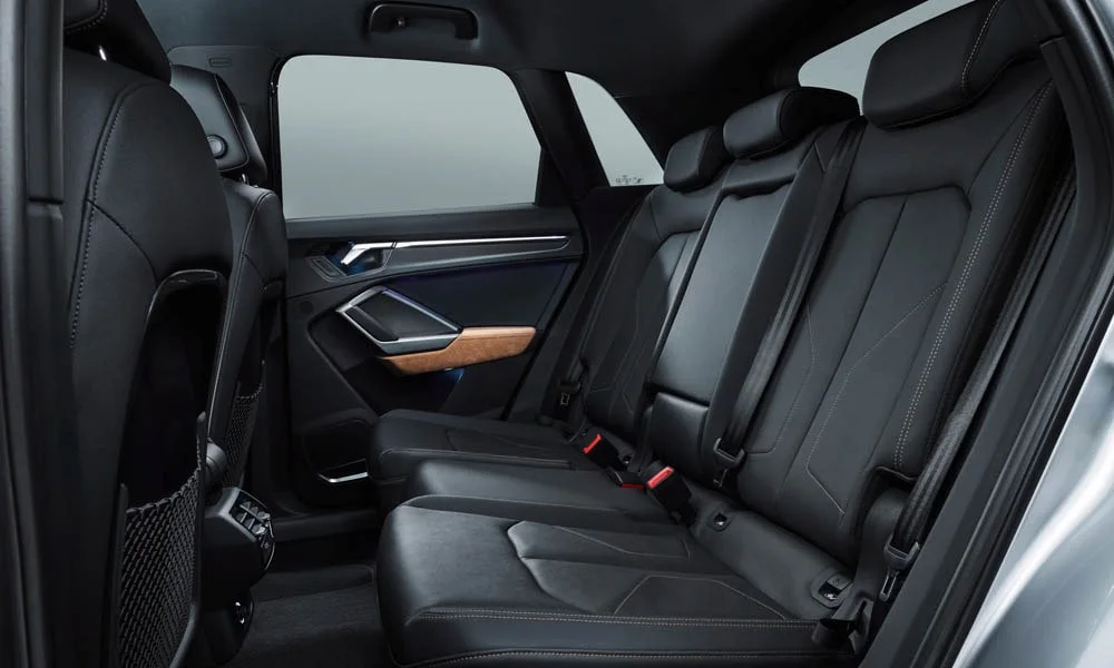 Фото Audi Q3 — задние сиденья. Посадка второго ряда: подголовники и подлокотник. Крепления ISOFIX для детских кресел — в основании спинки Audi Q3 — задние сиденья