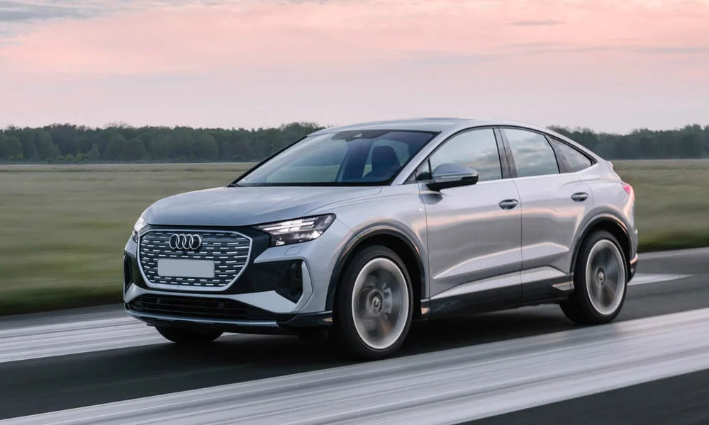 Фото Audi Q4 e-tron Sportback (2024) — вид спереди, фото 9. Передок в серебристом исполнении — крупная светотехника и выразительный бампер Audi Q4 e-tron Sportback (2024) — вид спереди, фото 9