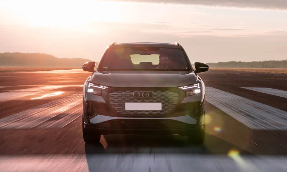 Фото Audi Q4 e-tron (2024) — вид спереди, фото 5. Анфас: пропорции капота, посадка кузова и графика ходовых огней. Рисунок ходовых огней — подпись модели, по нему её узнают в потоке Audi Q4 e-tron (2024) — вид спереди, фото 5