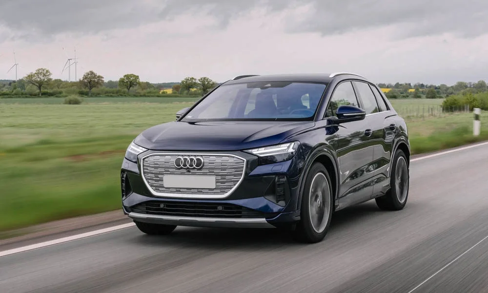 Фото Audi Q4 e-tron (2024) — вид спереди, фото 7. Синий кузов, строгая симметрия оптики — базовый ракурс знакомства с дизайном Audi Q4 e-tron (2024) — вид спереди, фото 7