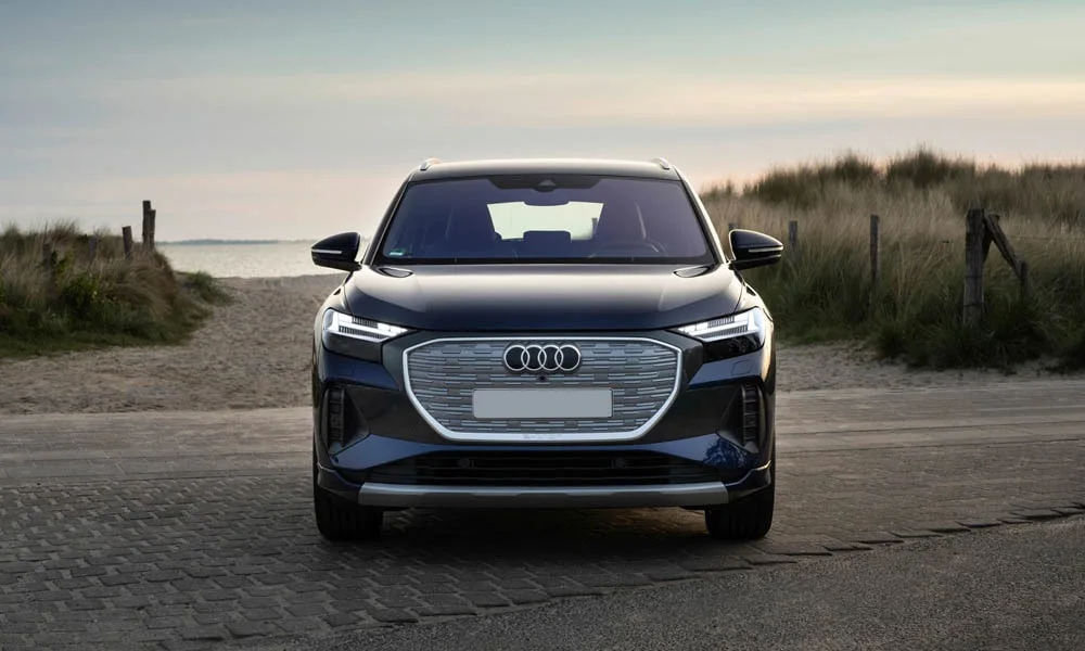 Фото Audi Q4 e-tron (2024) — вид спереди, фото 9. Анфас: пропорции капота, посадка кузова и графика ходовых огней. Рисунок ходовых огней — подпись модели, по нему её узнают в потоке Audi Q4 e-tron (2024) — вид спереди, фото 9