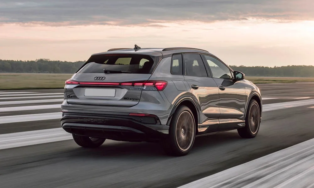 Фото Audi Q4 e-tron (2024) — вид сзади, фото 4. Серый кузов сзади — фонари и бампер определяют ночной образ модели. Насадки выхлопа или их имитация внизу бампера различают версии Audi Q4 e-tron (2024) — вид сзади, фото 4
