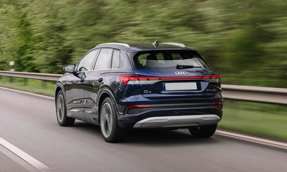 Фото Audi Q4 e-tron (2024) — вид сзади, фото 5. Линия крыши, стойки и задняя дверь в синем исполнении. Светодиодная полоса или раздельные секции — задняя оптика стала главным украшением кормы Audi Q4 e-tron (2024) — вид сзади, фото 5
