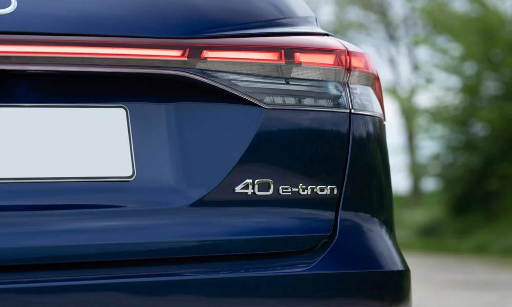 Фото Audi Q4 e-tron (2024) — вид сзади, фото 9. Корма в синем цвете: графика фонарей и пластика пятой двери. Светодиодная полоса или раздельные секции — задняя оптика стала главным украшением кормы Audi Q4 e-tron (2024) — вид сзади, фото 9