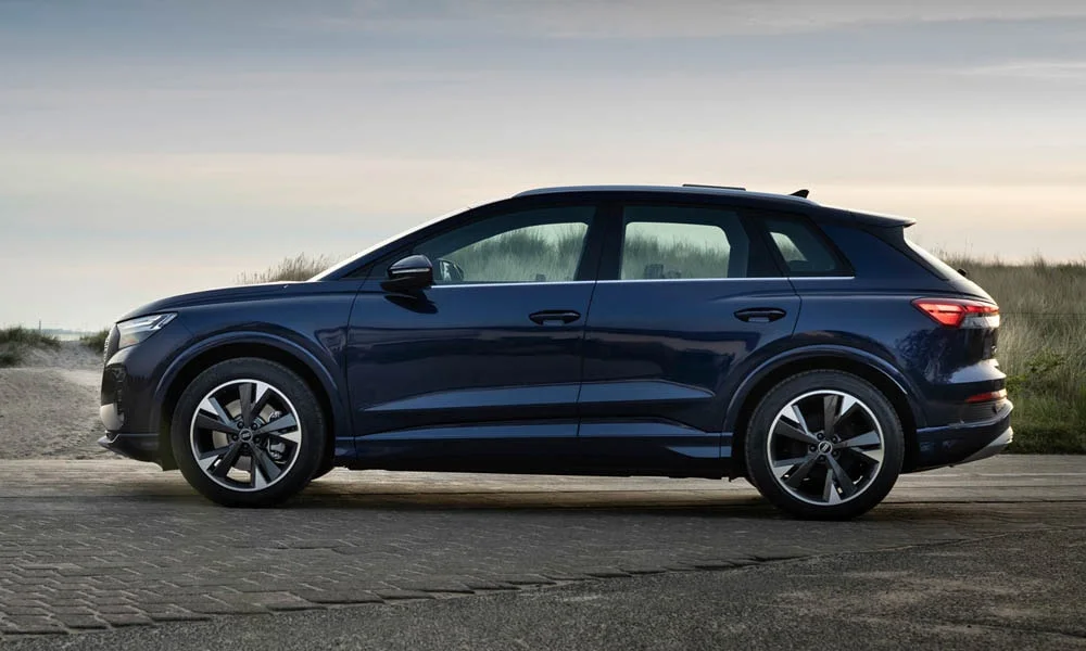 Фото Audi Q4 e-tron (2024) — вид сбоку, фото 2. Профиль кузова: колёсная база, свесы и линия остекления. Хромированные или чёрные молдинги окон отличают комплектации Audi Q4 e-tron (2024) — вид сбоку, фото 2