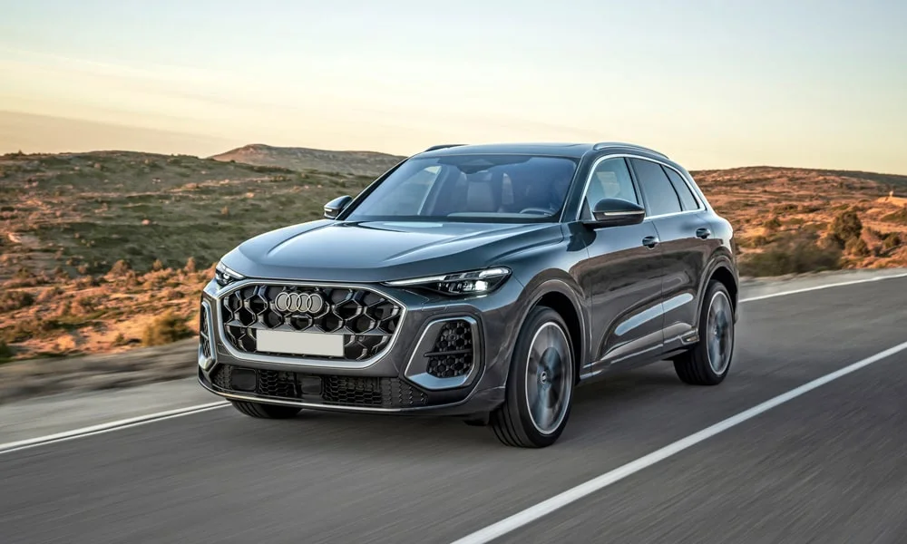 Фото Audi Q5 (2024) — вид спереди, фото 3. Передок в сером исполнении — крупная светотехника и выразительный бампер. Рисунок ходовых огней — подпись модели, по нему её узнают в потоке Audi Q5 (2024) — вид спереди, фото 3