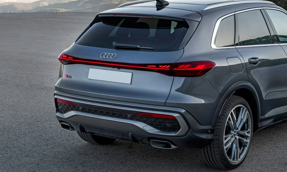 Фото Audi Q5 (2024) — вид сзади, фото 6. Корма в сером цвете: графика фонарей и пластика пятой двери. Насадки выхлопа или их имитация внизу бампера различают версии Audi Q5 (2024) — вид сзади, фото 6