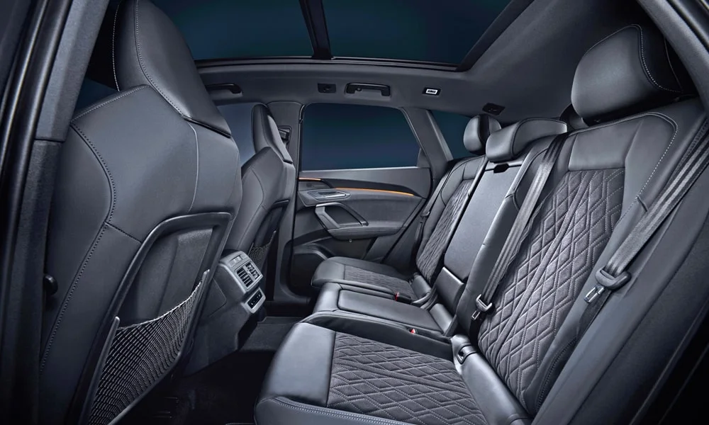 Фото Audi Q5 (2024) — задние сиденья. Посадка второго ряда: подголовники и подлокотник. Плоский пол упрощает посадку втроём Audi Q5 (2024) — задние сиденья