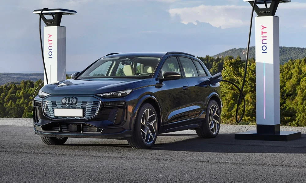 Фото Audi Q6 e-tron (2024) — вид спереди, фото 10. Анфас: пропорции капота, посадка кузова и графика ходовых огней. Рисунок ходовых огней — подпись модели, по нему её узнают в потоке Audi Q6 e-tron (2024) — вид спереди, фото 10