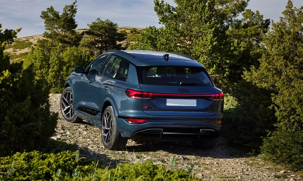 Фото Audi Q6 e-tron (2024) — вид сзади, фото 5. Линия крыши, стойки и задняя дверь в синем исполнении. Насадки выхлопа или их имитация внизу бампера различают версии Audi Q6 e-tron (2024) — вид сзади, фото 5