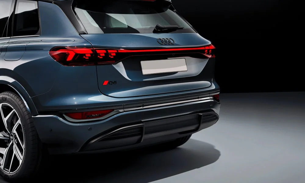 Фото Audi Q6 e-tron (2024) — вид сзади, фото 8. Корма в сером цвете: графика фонарей и пластика пятой двери. Светодиодная полоса или раздельные секции — задняя оптика стала главным украшением кормы Audi Q6 e-tron (2024) — вид сзади, фото 8