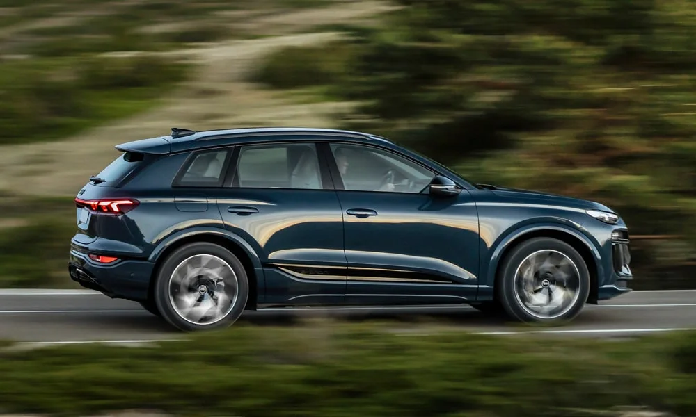Фото Audi Q6 e-tron (2024) — вид сбоку, фото 3. Синий кузов в профиль — пропорции, высота посадки и дизайн дисков. Хромированные или чёрные молдинги окон отличают комплектации Audi Q6 e-tron (2024) — вид сбоку, фото 3