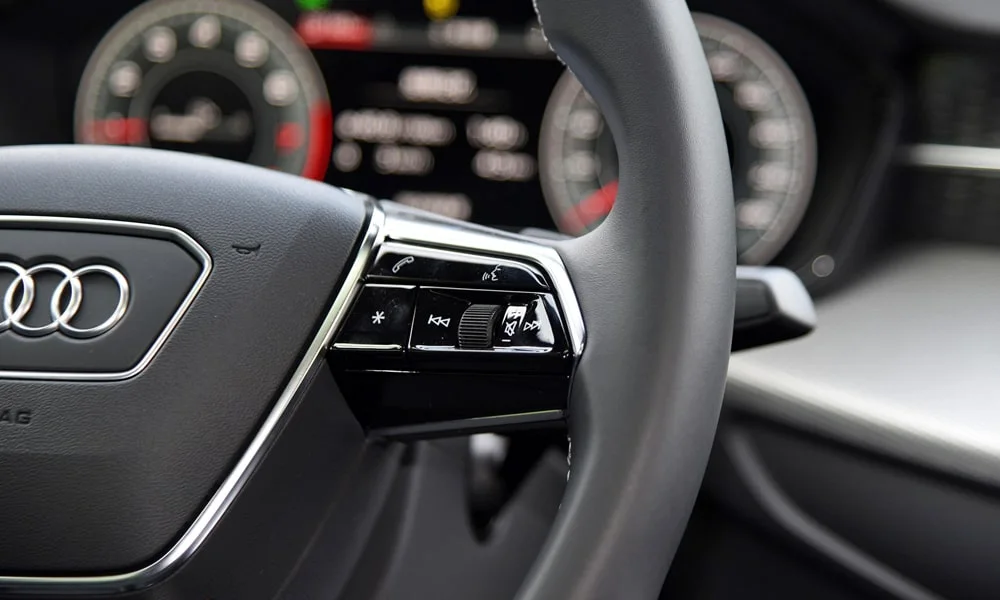 Фото Audi Q6 (2024) — руль, фото 3. Обшивка обода и компоновка спиц крупным планом. Правильная посадка: руки на «9 и 3», приборы читаются поверх обода Audi Q6 (2024) — руль, фото 3