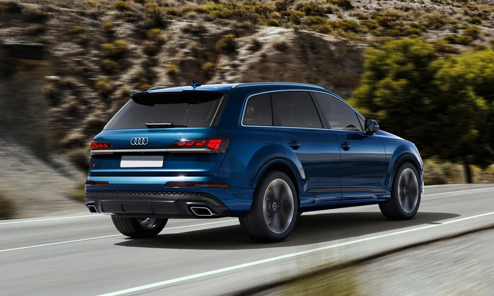 Фото Audi Q7 (2024) — вид сзади, фото 6. Синий кузов сзади — фонари и бампер определяют ночной образ модели Audi Q7 (2024) — вид сзади, фото 6