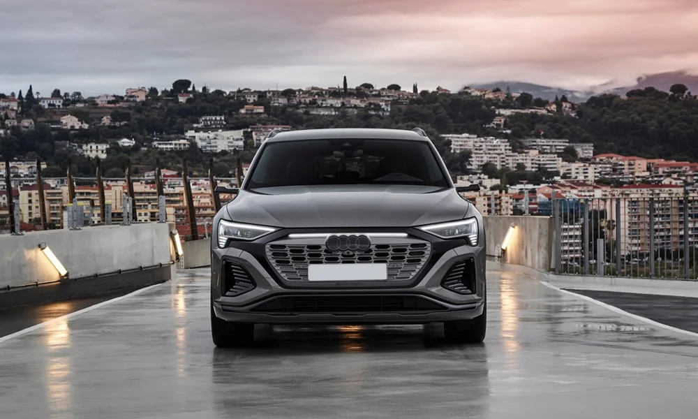 Фото Audi Q8 e-tron (2024) — вид спереди, фото 5. Анфас: пропорции капота, посадка кузова и графика ходовых огней. Дневные ходовые огни включаются автоматически с запуском Audi Q8 e-tron (2024) — вид спереди, фото 5