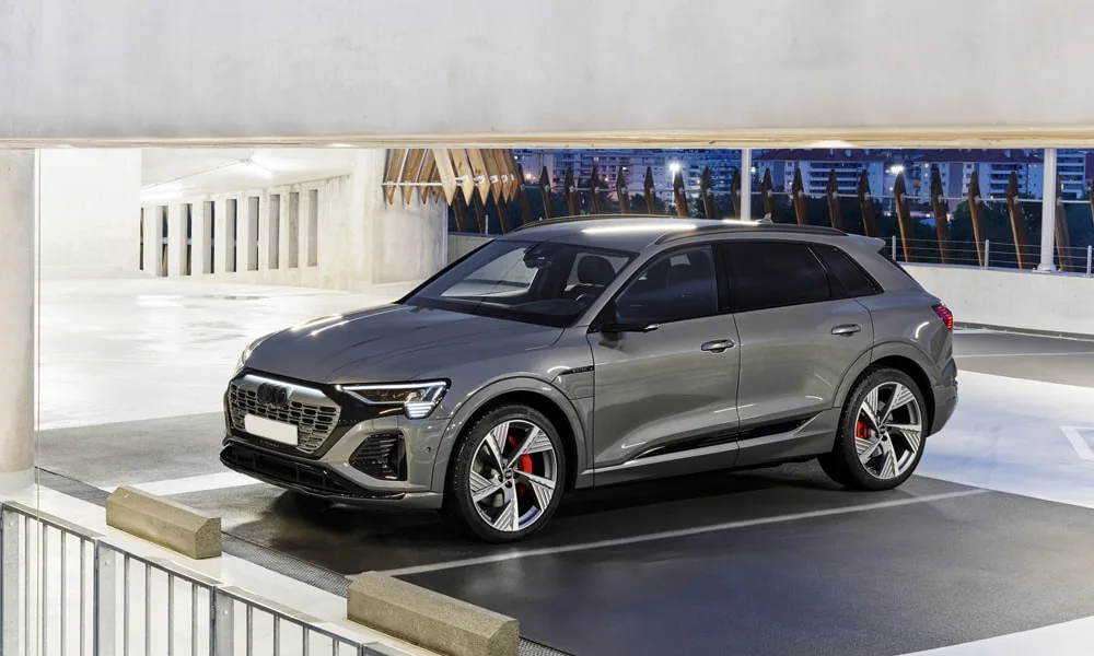 Фото Audi Q8 e-tron (2024) — вид спереди, фото 6. Передок в сером исполнении — крупная светотехника и выразительный бампер. Рисунок ходовых огней — подпись модели, по нему её узнают в потоке Audi Q8 e-tron (2024) — вид спереди, фото 6