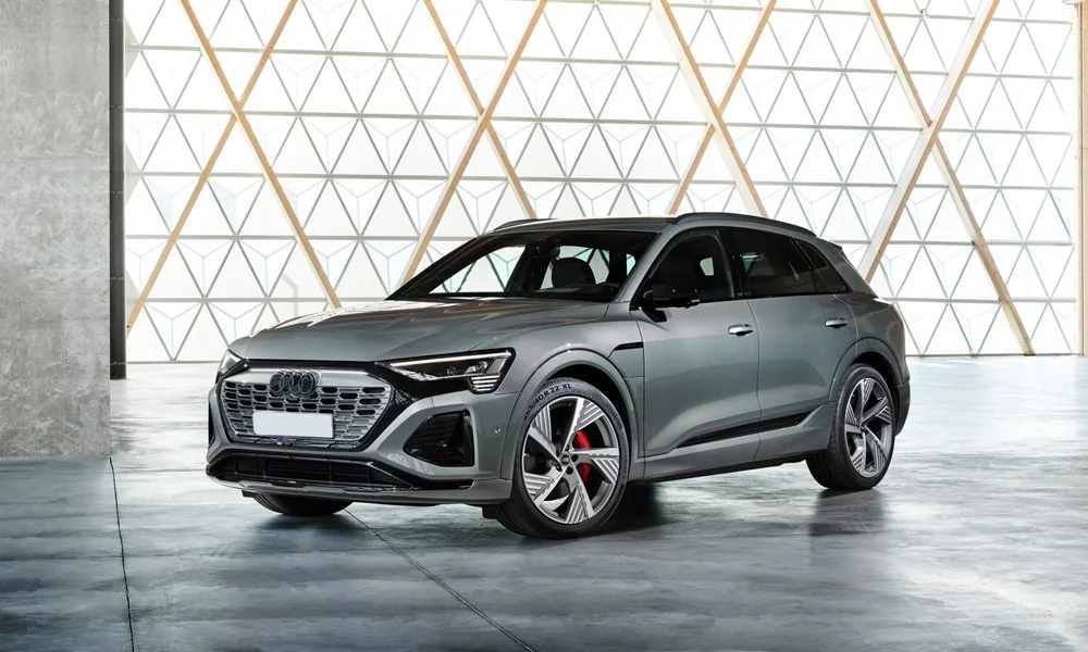 Фото Audi Q8 e-tron (2024) — вид спереди, фото 8. Передок в сером исполнении — крупная светотехника и выразительный бампер. Дневные ходовые огни включаются автоматически с запуском Audi Q8 e-tron (2024) — вид спереди, фото 8