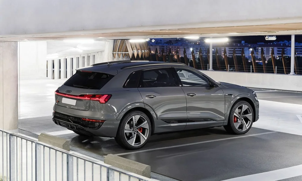 Фото Audi Q8 e-tron (2024) — вид сзади, фото 5. Серый кузов сзади — фонари и бампер определяют ночной образ модели. Насадки выхлопа или их имитация внизу бампера различают версии Audi Q8 e-tron (2024) — вид сзади, фото 5