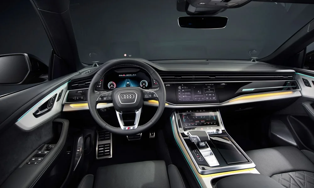 Фото Audi Q8 (2024) — передняя панель. Панель в тёмной отделке — видна компоновка экранов и органов управления. Мягкие материалы верхнего яруса и вставки задают уровень интерьера Audi Q8 (2024) — передняя панель