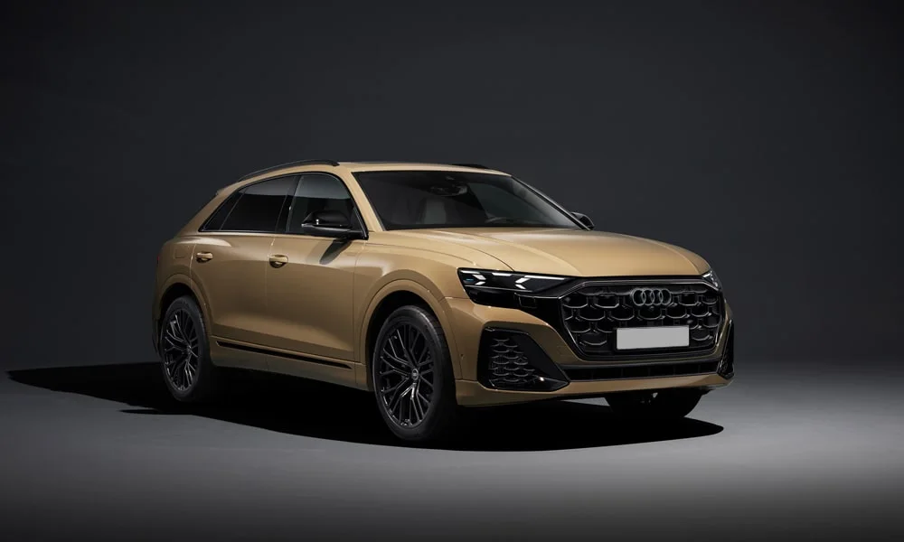 Фото Audi Q8 (2024) — вид спереди, фото 6. Золотистый кузов, строгая симметрия оптики — базовый ракурс знакомства с дизайном Audi Q8 (2024) — вид спереди, фото 6