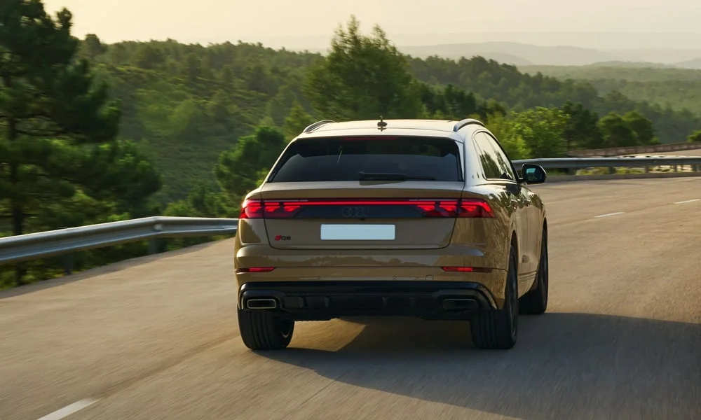 Фото Audi Q8 (2024) — вид сзади, фото 4. Корма в коричневом цвете: графика фонарей и пластика пятой двери. Светодиодная полоса или раздельные секции — задняя оптика стала главным украшением кормы Audi Q8 (2024) — вид сзади, фото 4