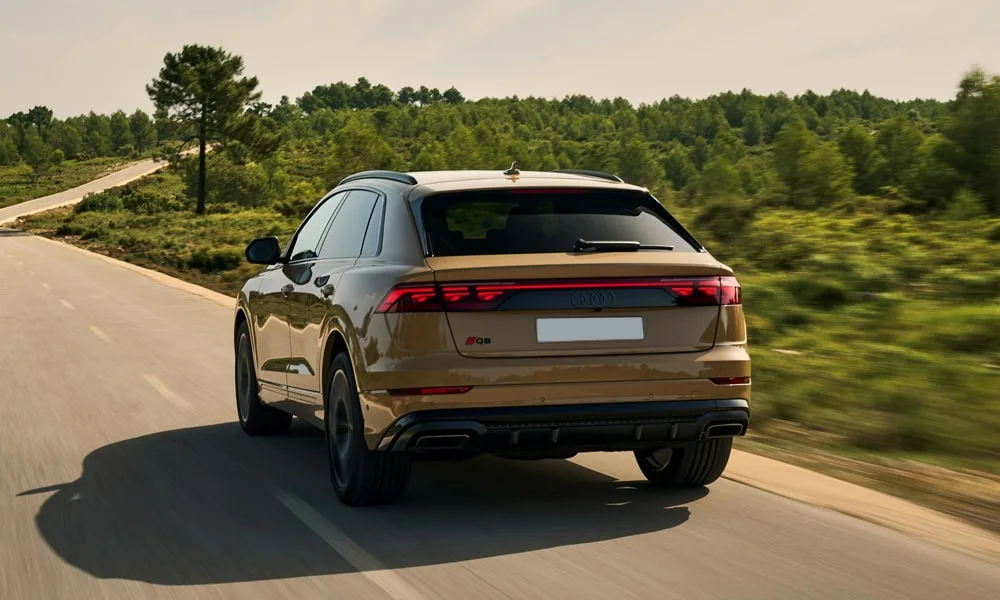 Фото Audi Q8 (2024) — вид сзади, фото 5. Корма в коричневом цвете: графика фонарей и пластика пятой двери. Насадки выхлопа или их имитация внизу бампера различают версии Audi Q8 (2024) — вид сзади, фото 5