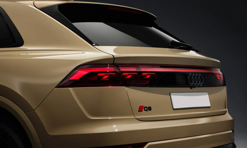 Фото Audi Q8 (2024) — вид сзади, фото 9. Линия крыши, стойки и задняя дверь в бежевом исполнении. Светодиодная полоса или раздельные секции — задняя оптика стала главным украшением кормы Audi Q8 (2024) — вид сзади, фото 9