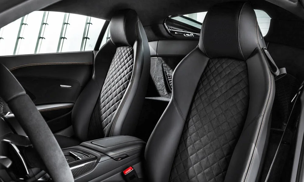 Фото Audi R8 (2024) — интерьер, фото 4. Общий план салона: архитектура панели, консоль и кресла. Светлая гамма зрительно расширяет салон, тёмная — практичнее в уходе Audi R8 (2024) — интерьер, фото 4