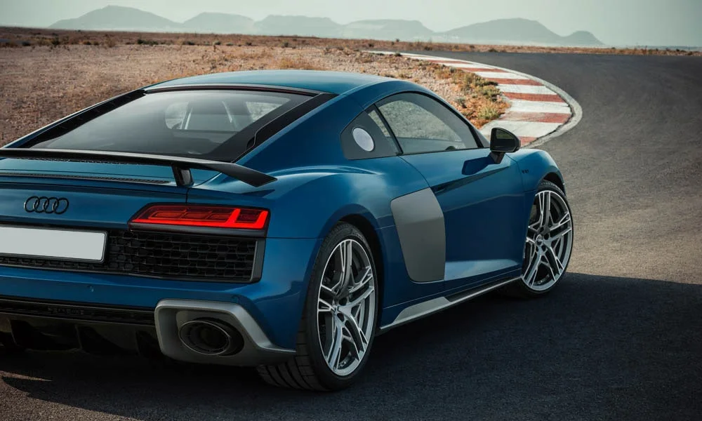 Фото Audi R8 (2024) — вид сзади, фото 4. Линия крыши, стойки и задняя дверь в синем исполнении. Светодиодная полоса или раздельные секции — задняя оптика стала главным украшением кормы Audi R8 (2024) — вид сзади, фото 4