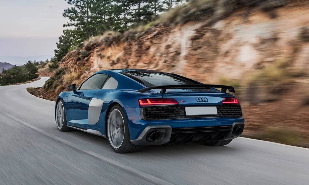 Фото Audi R8 (2024) — вид сзади, фото 8. Корма в синем цвете: графика фонарей и пластика пятой двери. Светодиодная полоса или раздельные секции — задняя оптика стала главным украшением кормы Audi R8 (2024) — вид сзади, фото 8